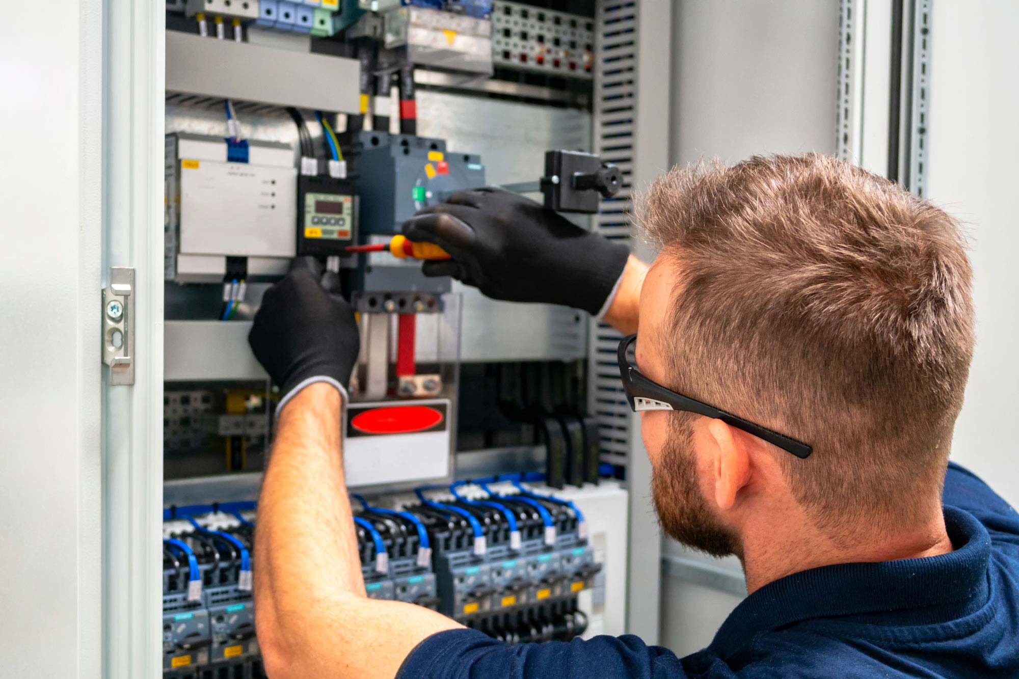 Elektriker som jobbar i ett elskåp