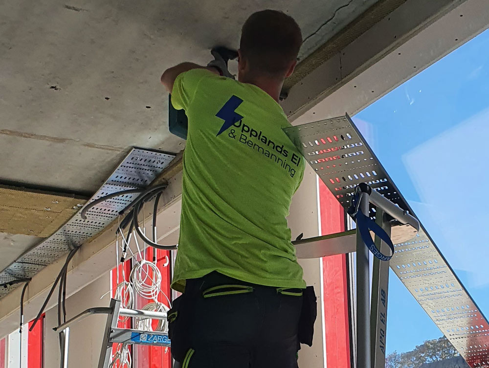 En elektriker står på en stege